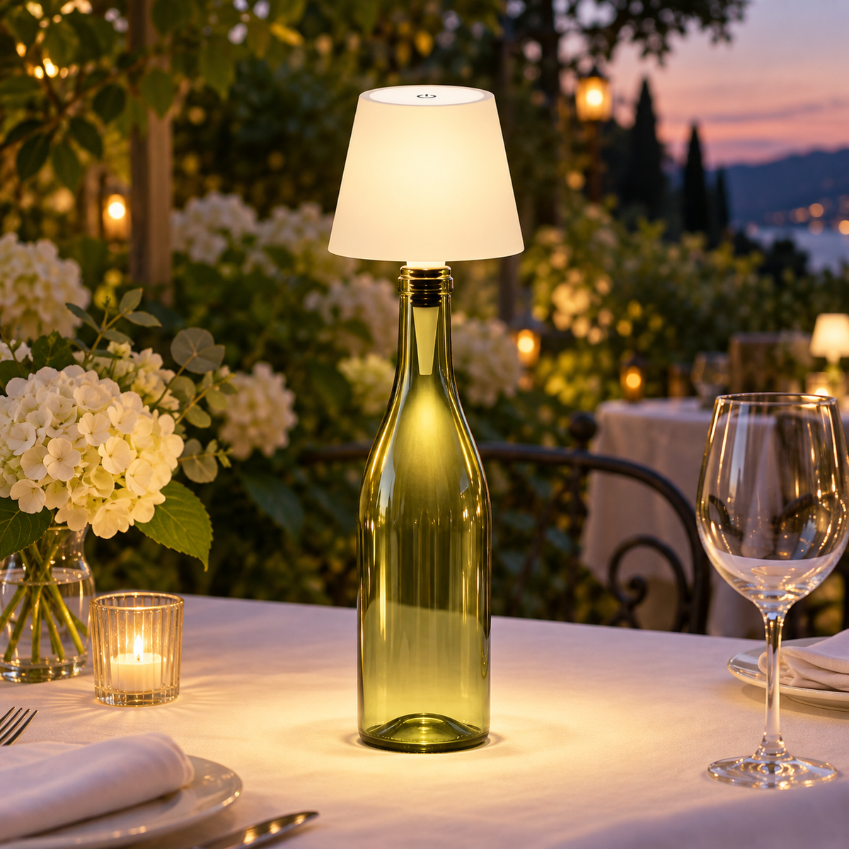 The Vesper in Pearl on a green wine bottle on a garden dinner table at dusk