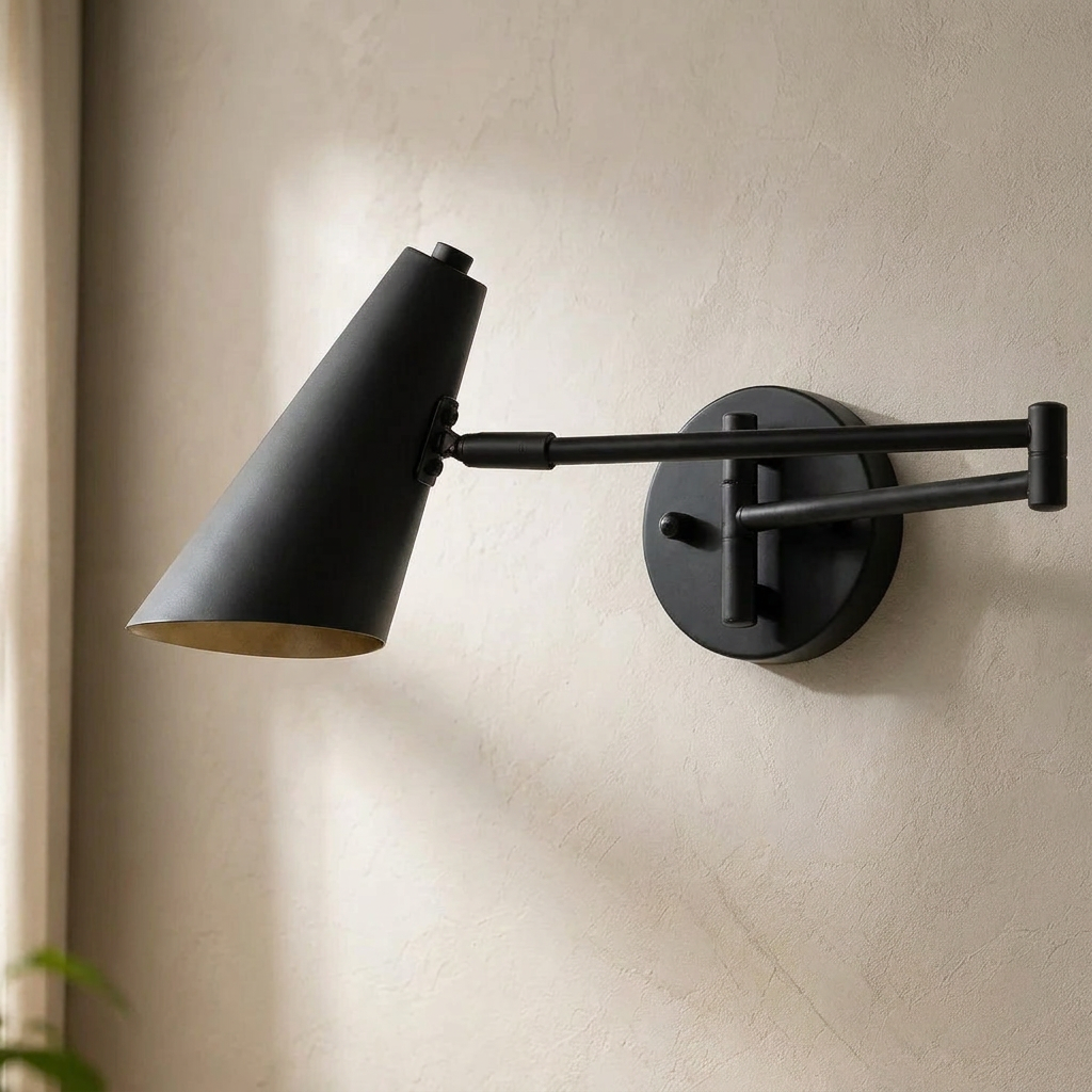 The Pivot, black industrial swing arm wall light with cone shade, mounted on plaster wall — Selden Home product photography