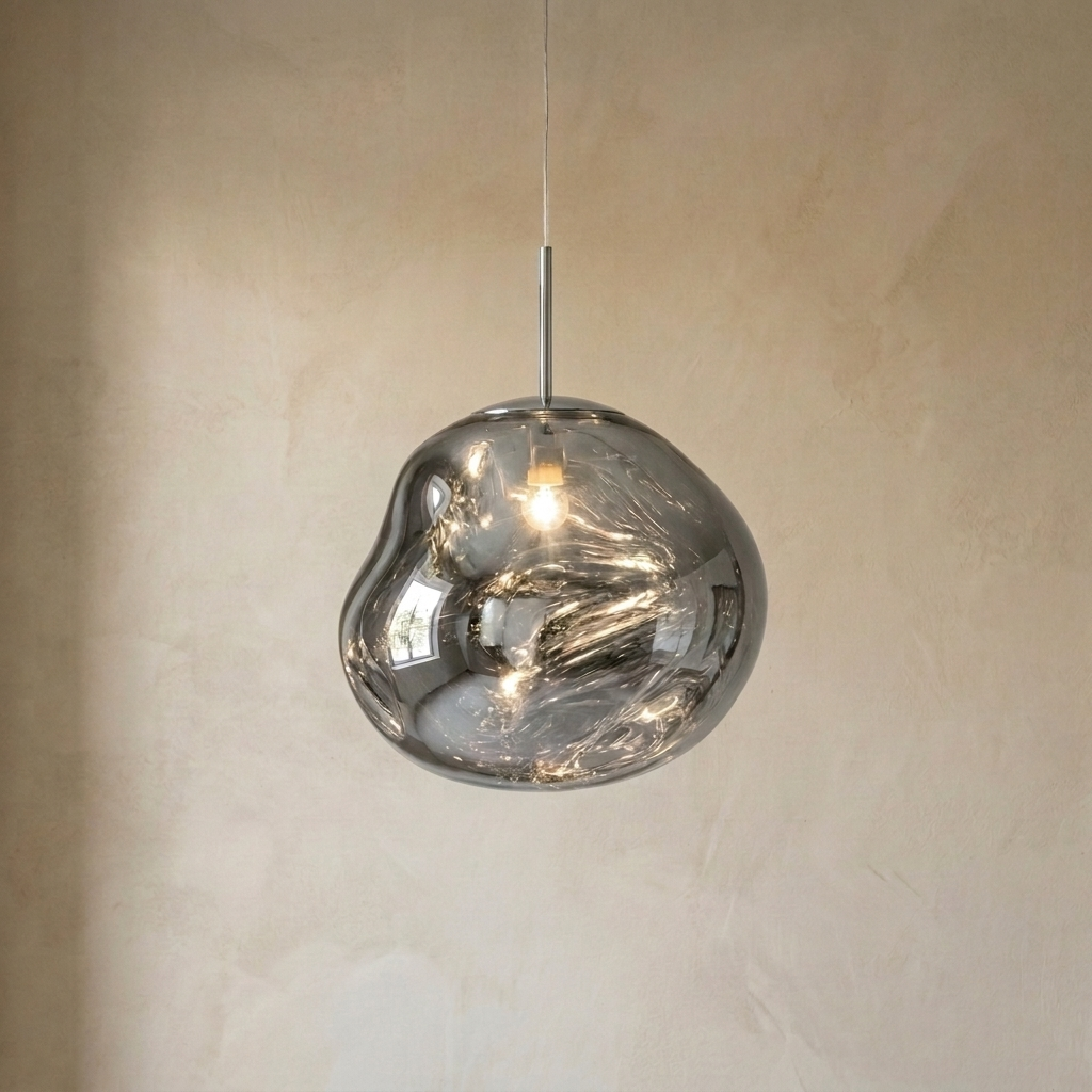 The Ember chrome molten acrylic pendant light with chrome fittings, lit, in front of a lime-washed plaster wall — Selden Home product photography