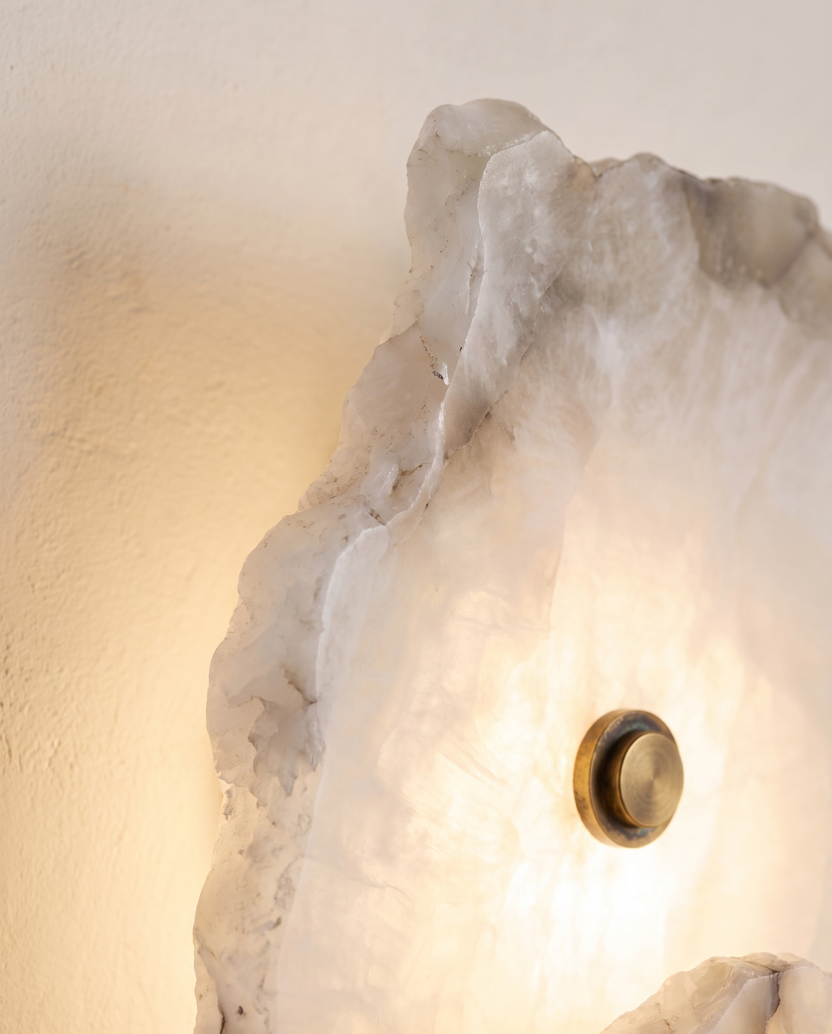 Close-up of The Strata's rough alabaster edge and brass fixing