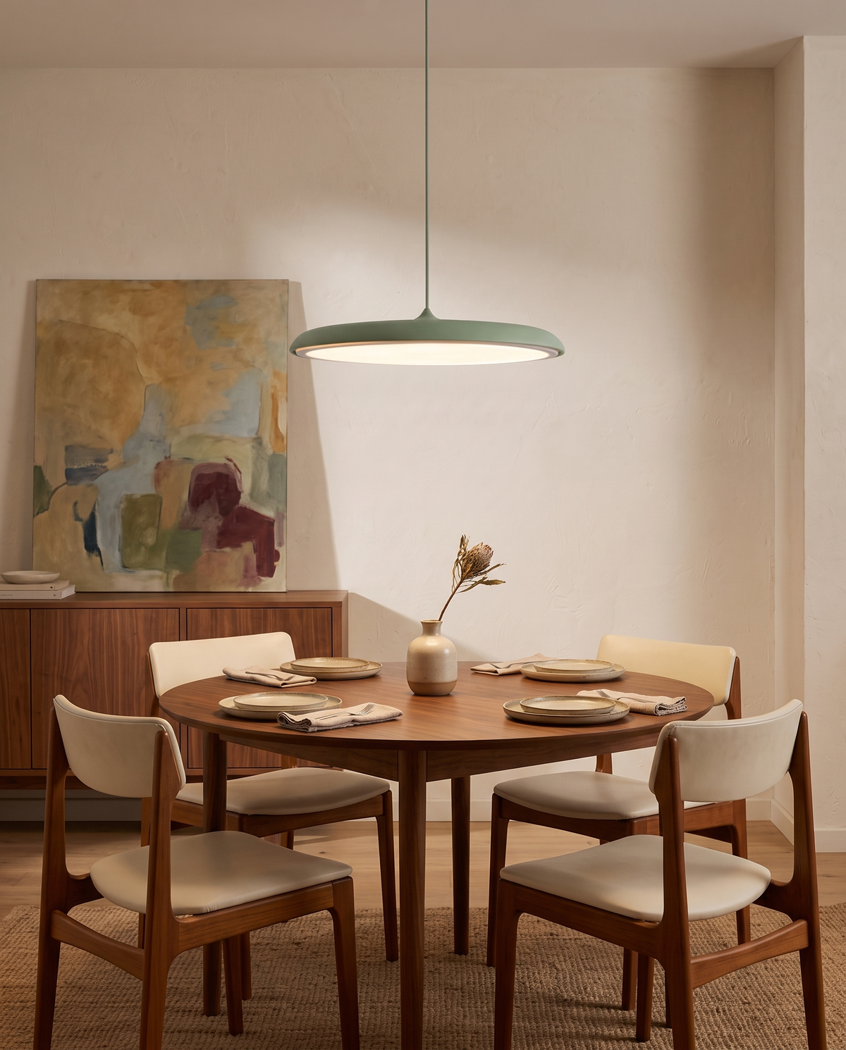 The Wafer Pendant in green over a round walnut dining table