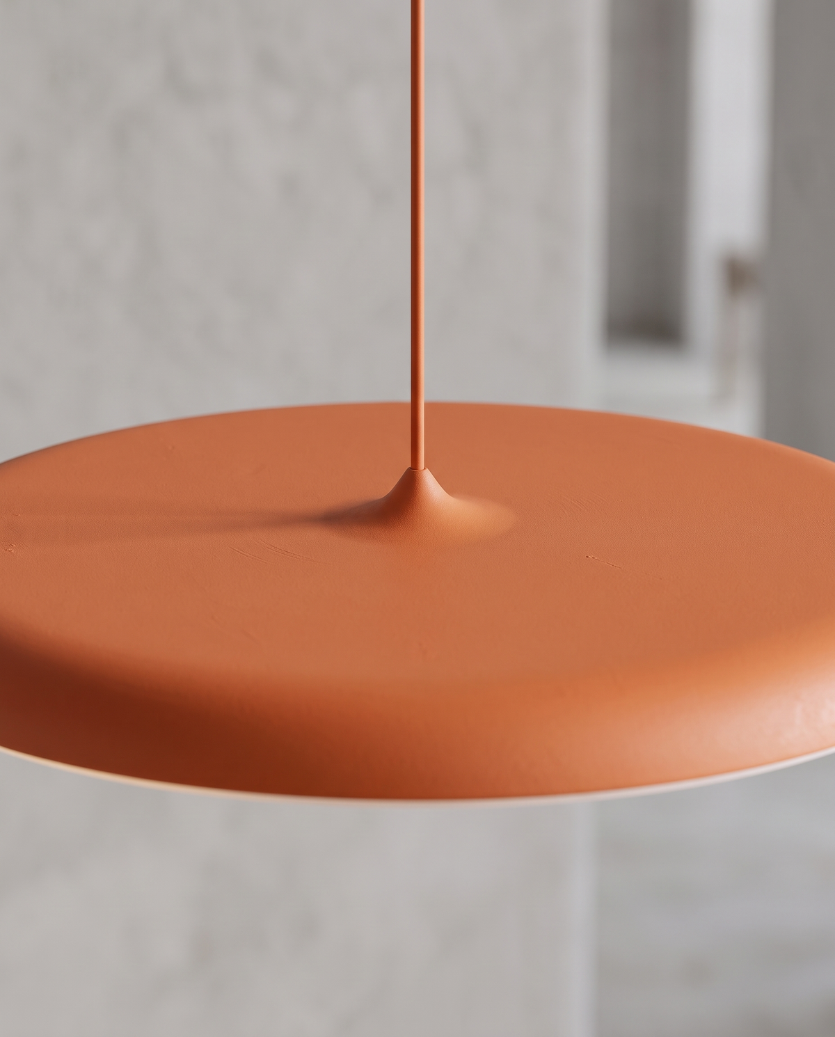 Close-up of The Wafer's slim orange disc and cord