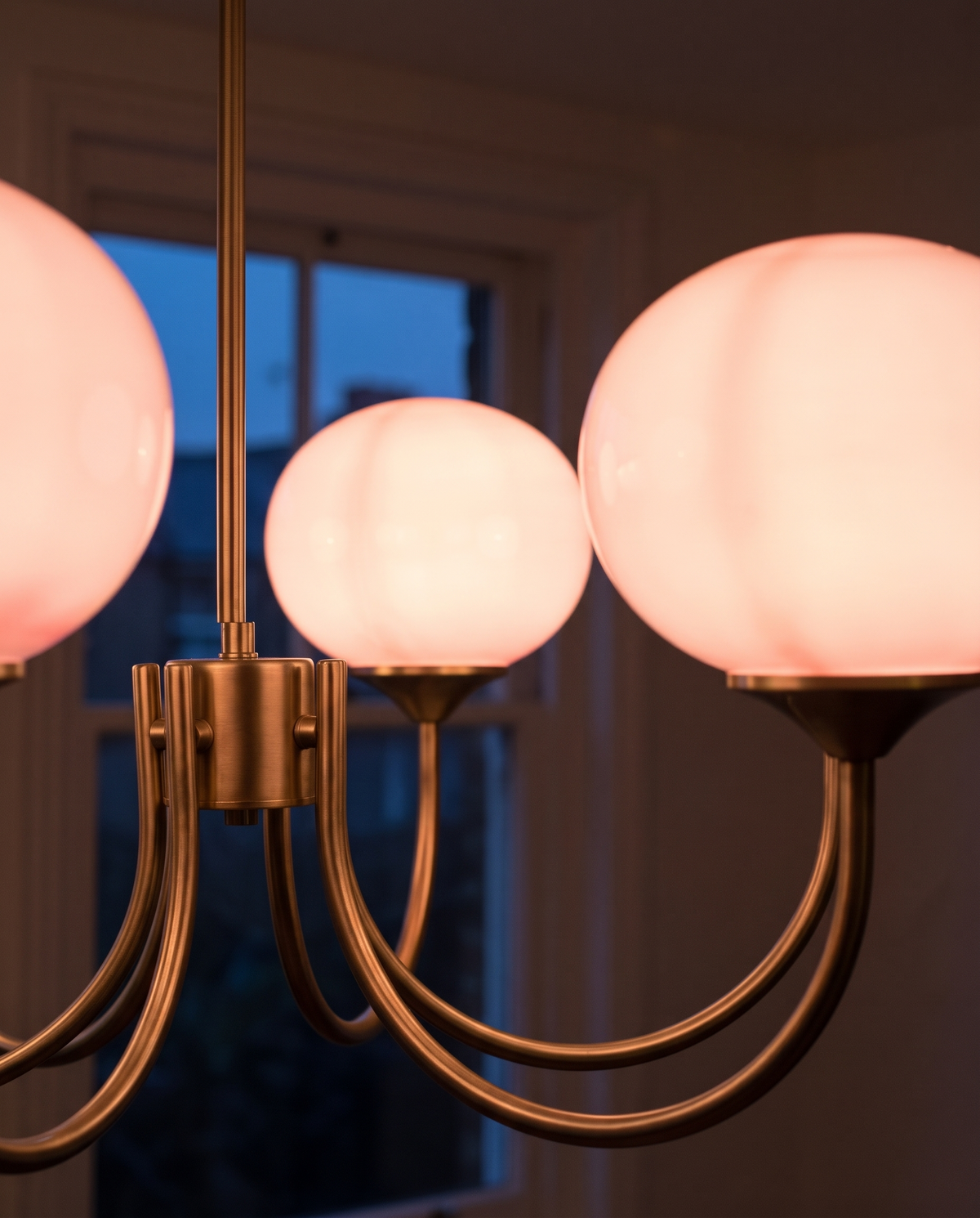 Close-up of the hand-sprayed rose glass globes and brass arms of The Bonbon