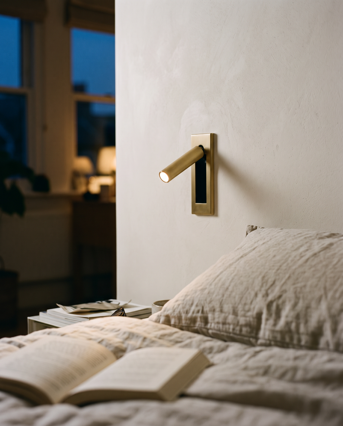 Close-up of the brushed brass Bookmark arm swinging out of its wall plate