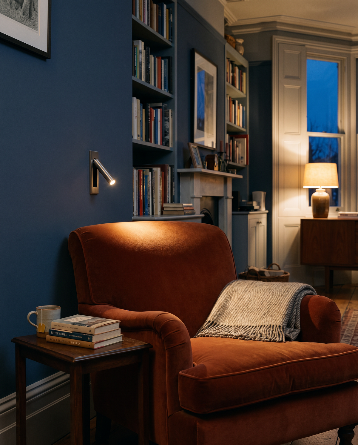 A Bookmark reading light beside a rust velvet armchair
