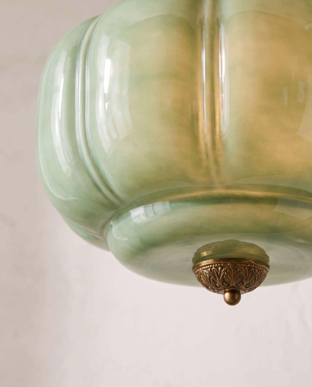 Close-up of the lobed jade glass and gold finial of The Jade