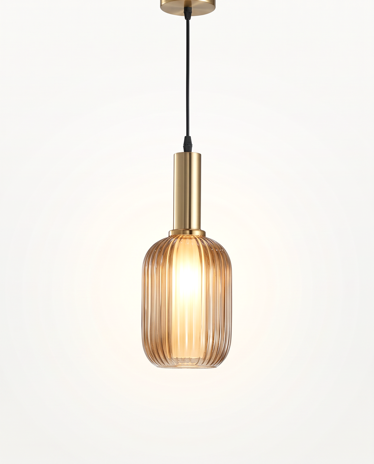 The Larder Pendant, slim, in amber ribbed glass with a brass-finish fitting, lit