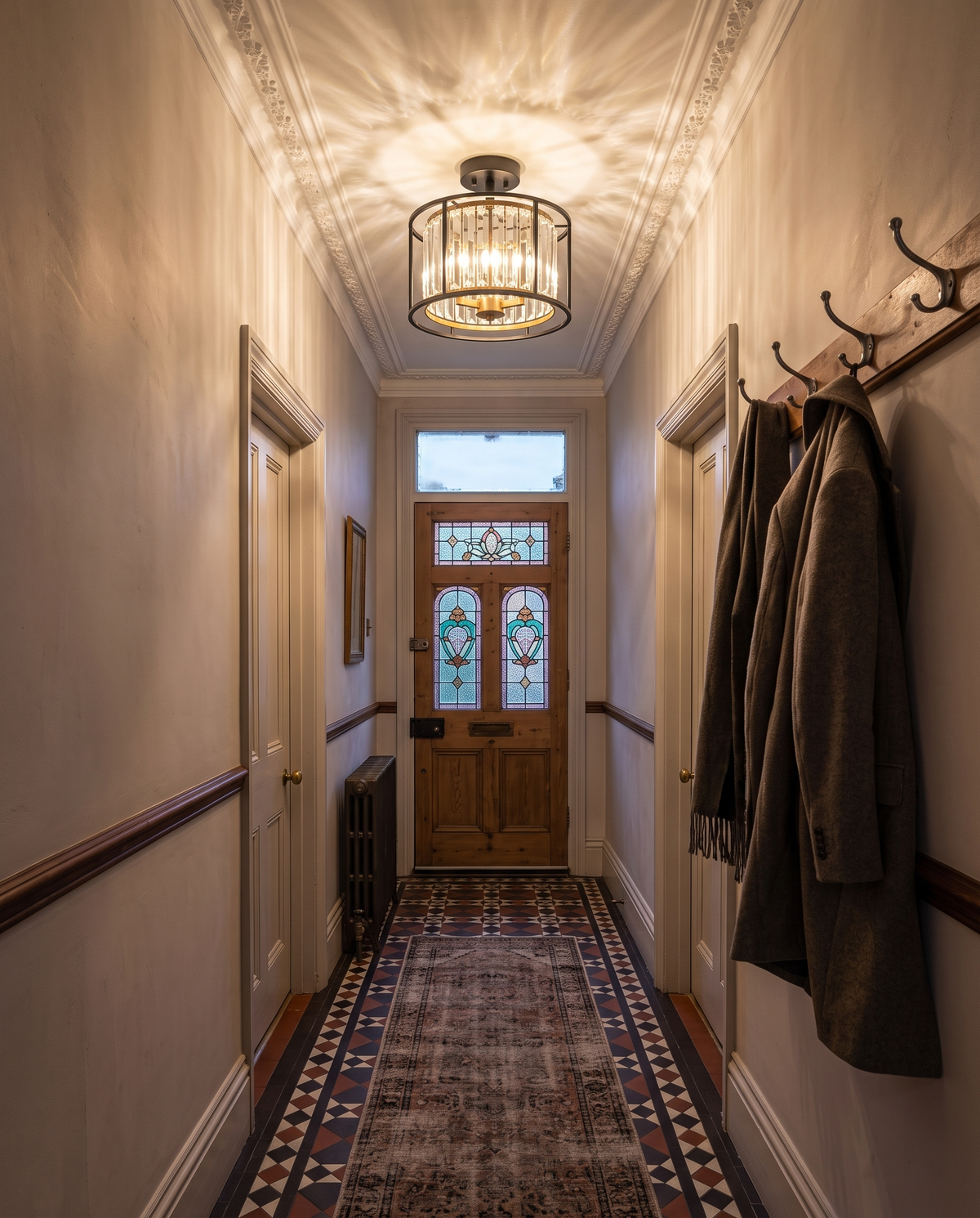 The Lustre on the ceiling of a Victorian terrace hallway with encaustic tiles