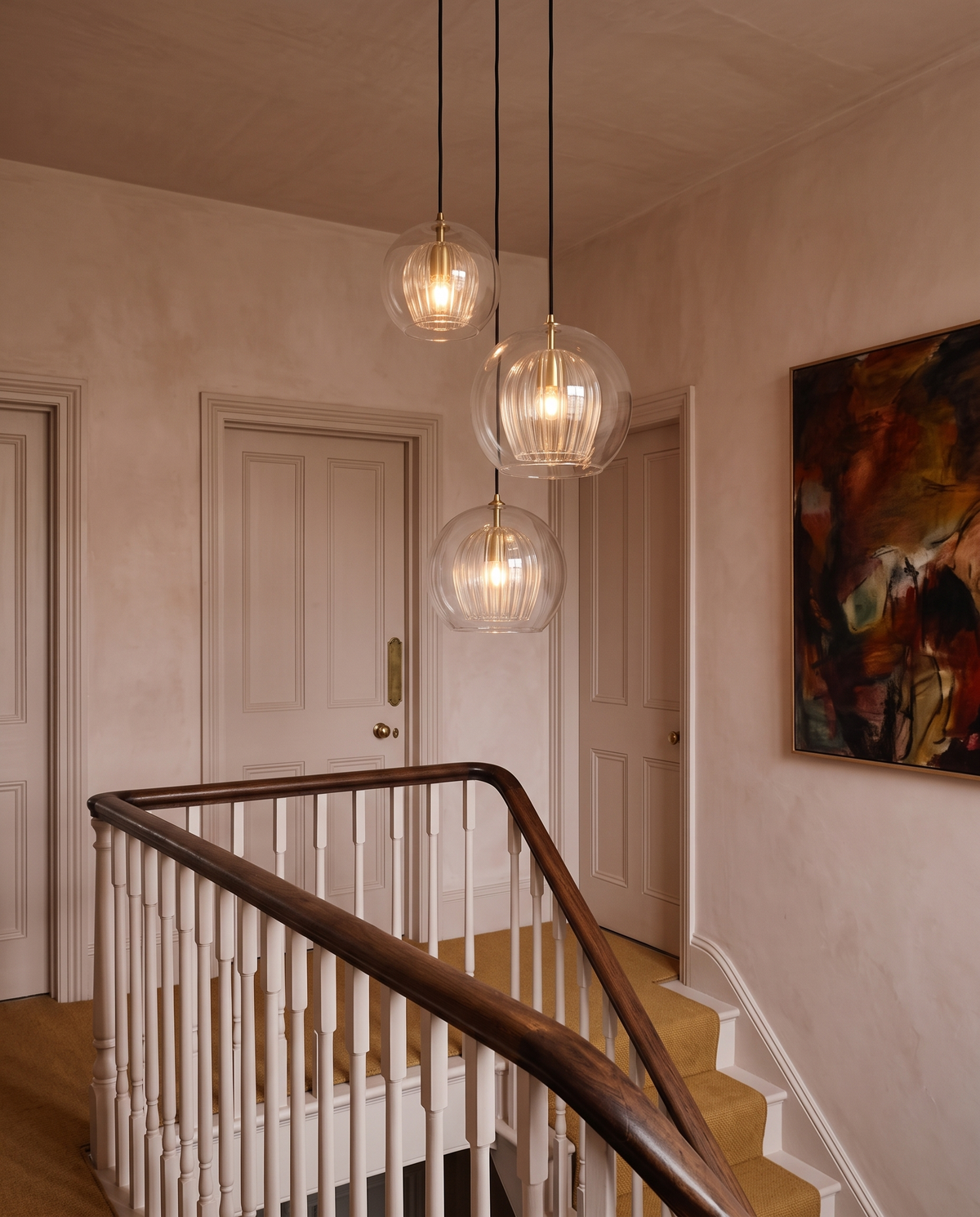 Three clear Nest pendants at staggered heights on an Edwardian landing