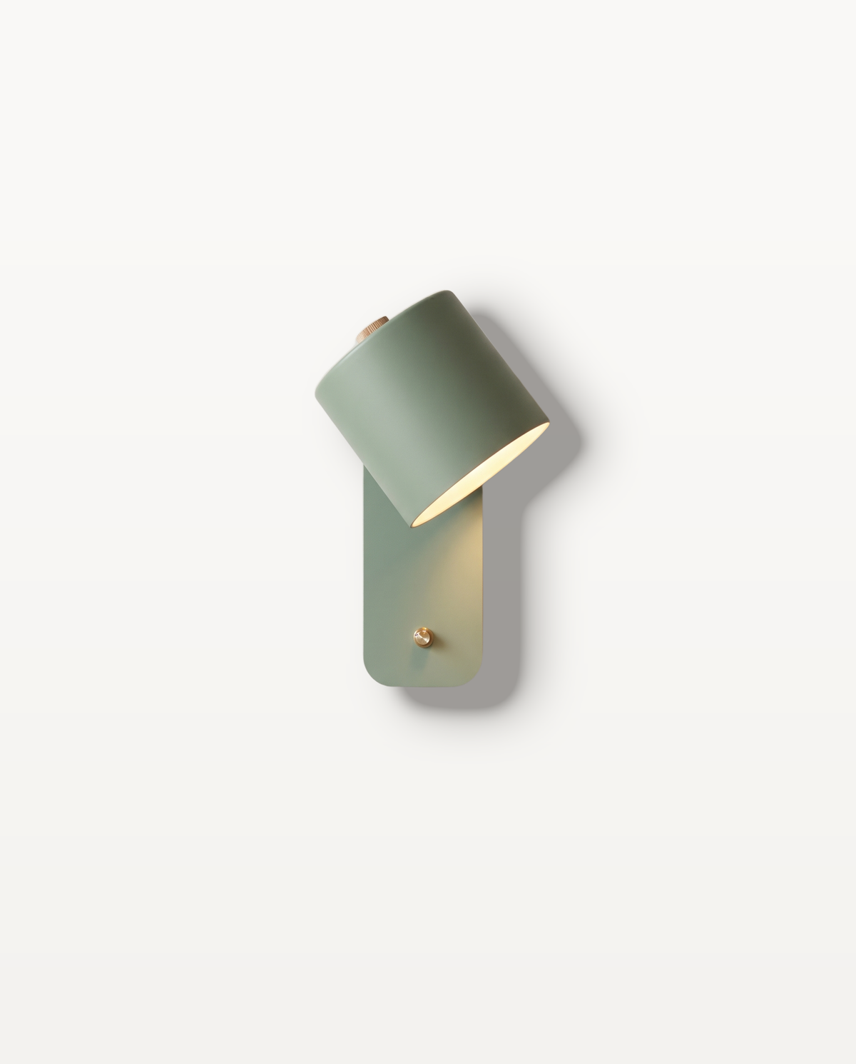 The Nightcap Wall Light, matte Sage cylinder shade on a slim wall plate, lit
