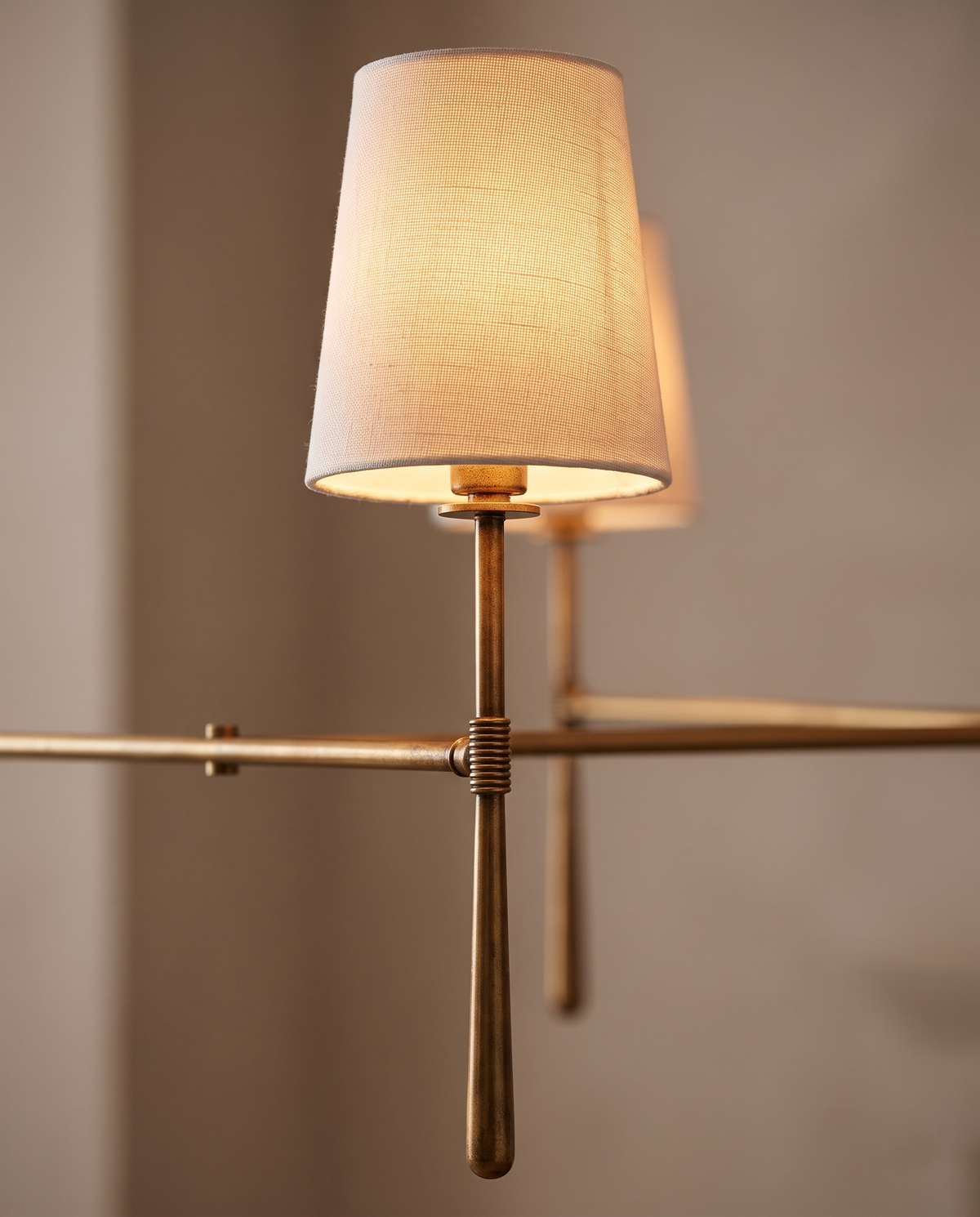 Close-up of a linen shade and tapered brass torch of The Salon