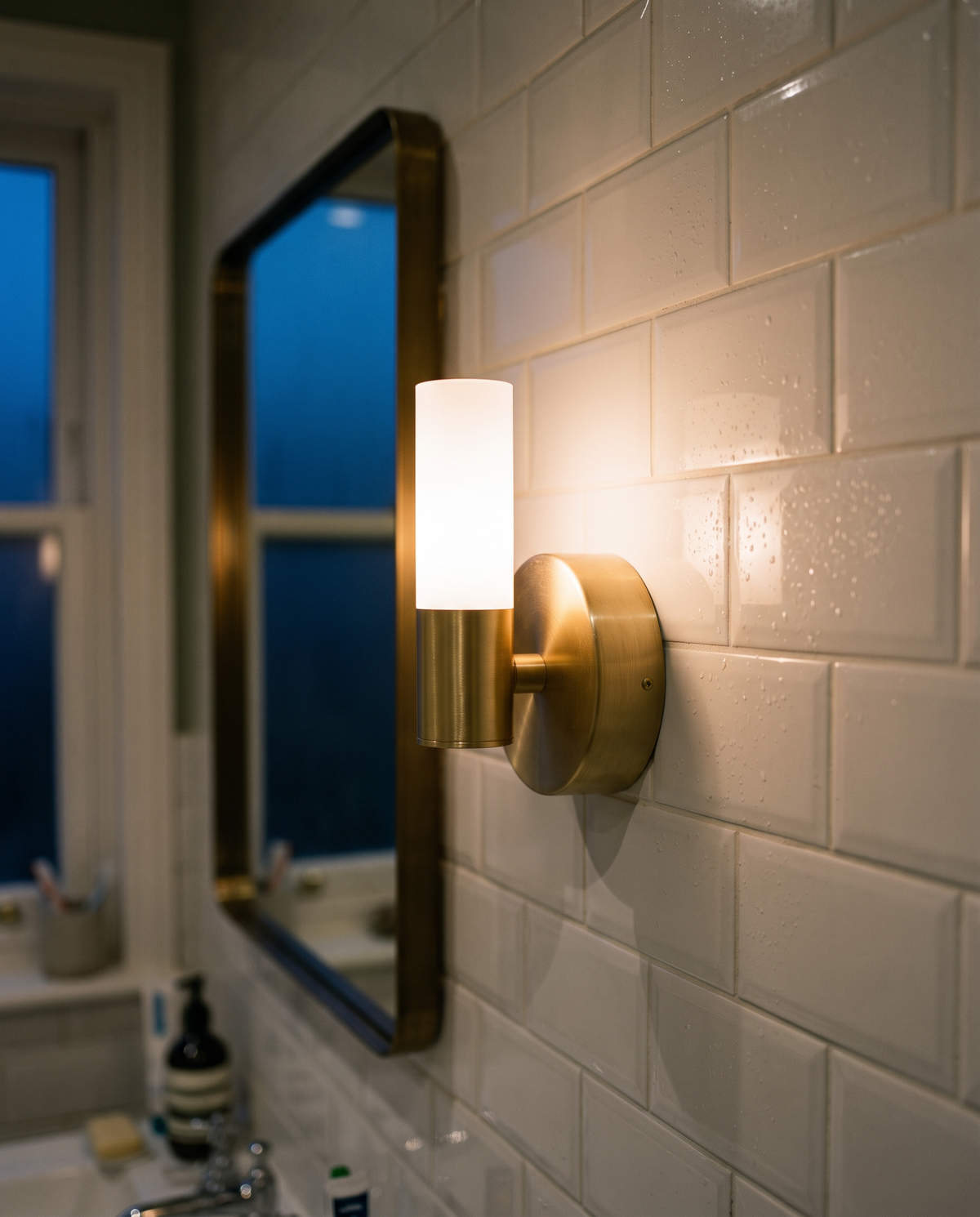 Close-up of the brushed brass plate and frosted tube of The Washstand