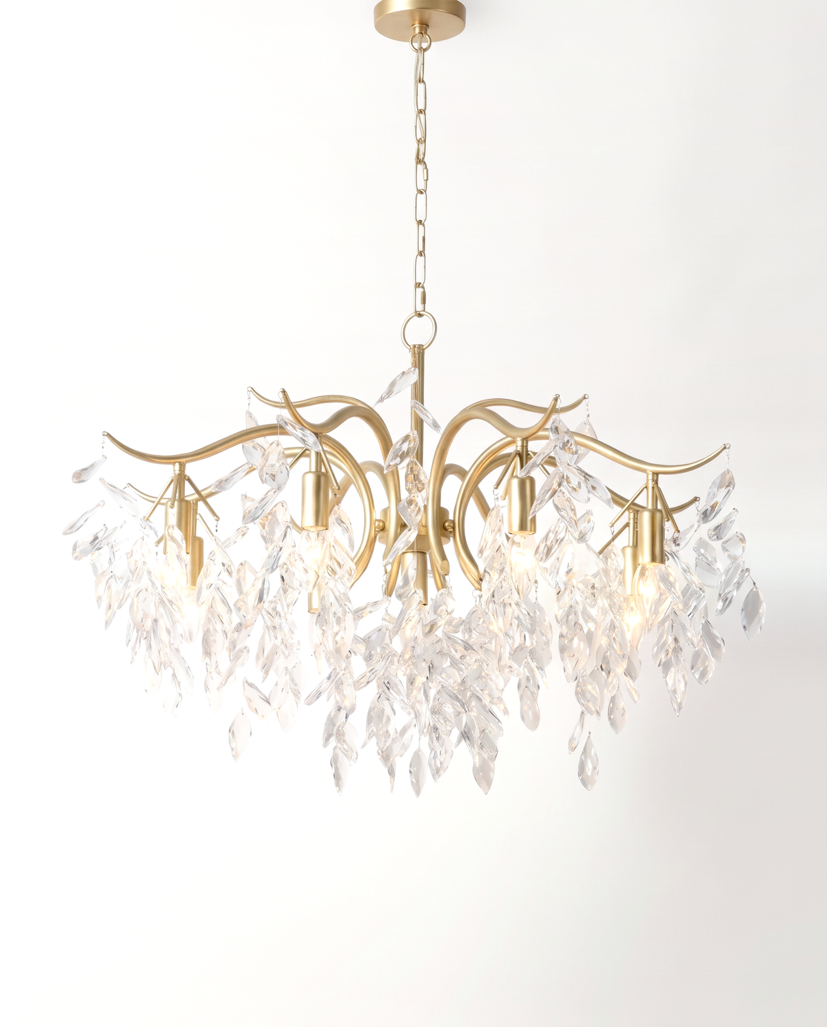 The Willow Chandelier in Gilt, crystal leaves on curving gold branches, lit
