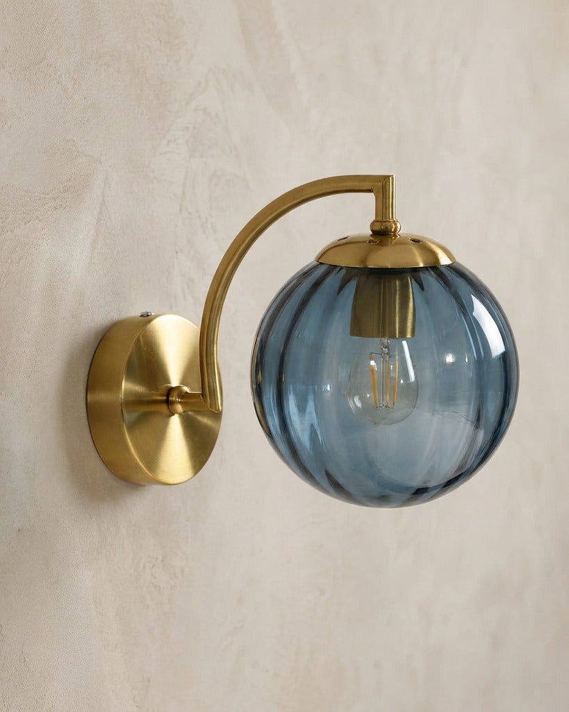 The Bloom, ribbed glass wall sconce, blue glass on gold arm, mounted on plaster wall — Selden Home product photography