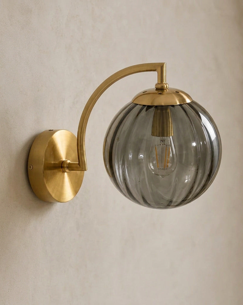 The Bloom, ribbed glass wall sconce, smoke grey glass on gold arm, mounted on plaster wall — Selden Home product photography