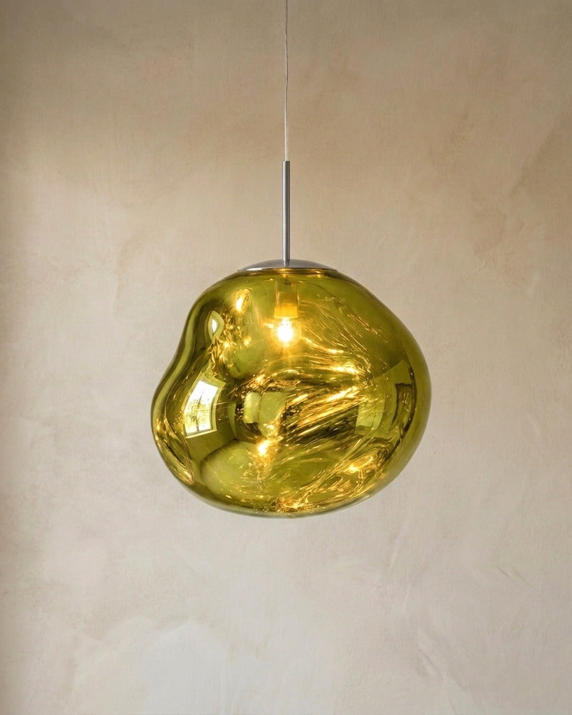 The Ember green molten acrylic pendant light with chrome fittings, lit, in front of a lime-washed plaster wall — Selden Home product photography