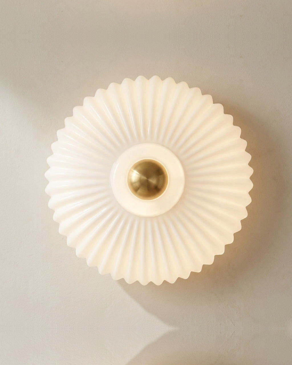 The Sunburst, ribbed white blown-glass wall light throwing a fan of light rays — Selden Home product photography
