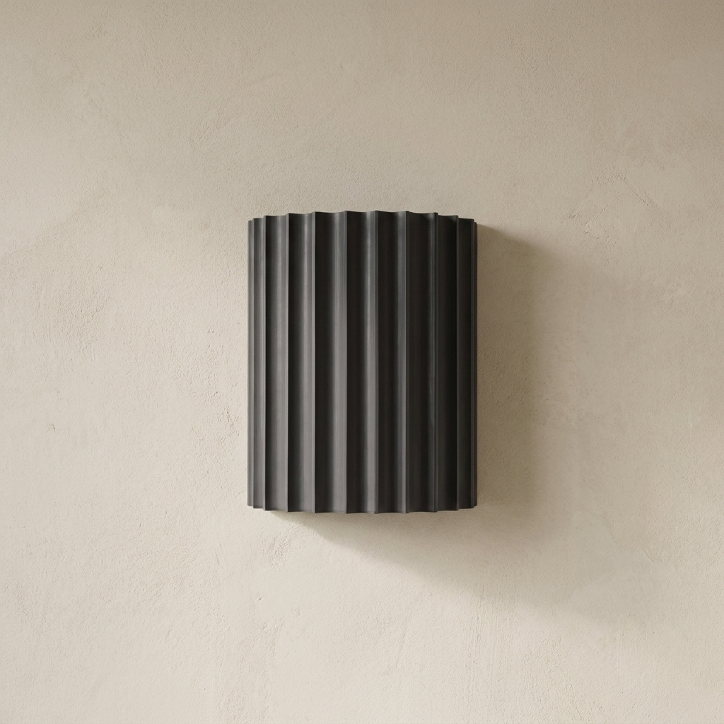 The Pleat, dark grey fluted wall light on lime-washed plaster wall — Selden Home product photography