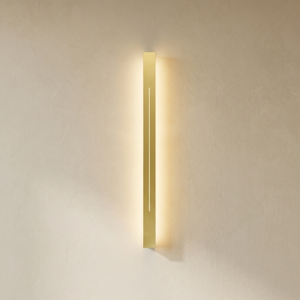 The Beam gold linear LED wall light, lit, on a lime-washed plaster wall — Selden Home product photography