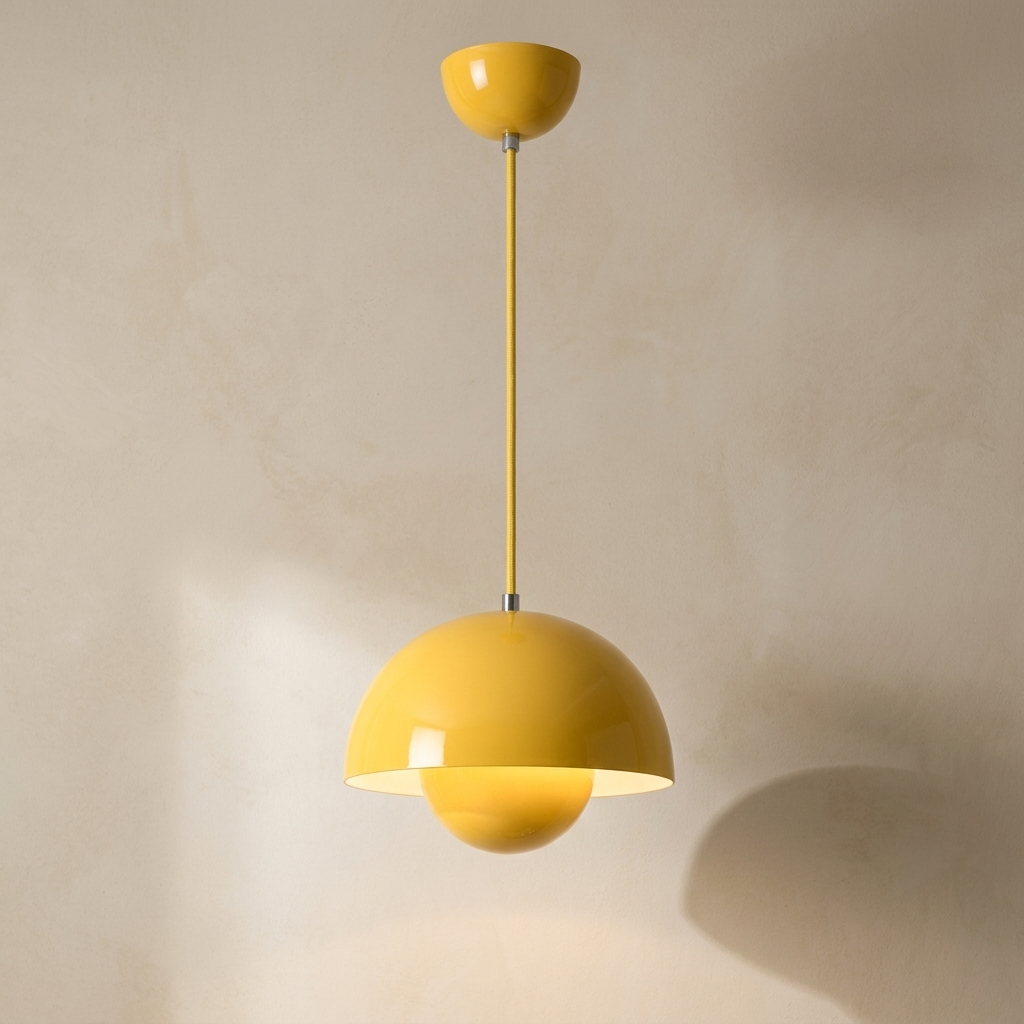 The Bonnet yellow mushroom pendant light, lit, hanging in front of a lime-washed plaster wall — Selden Home product photography