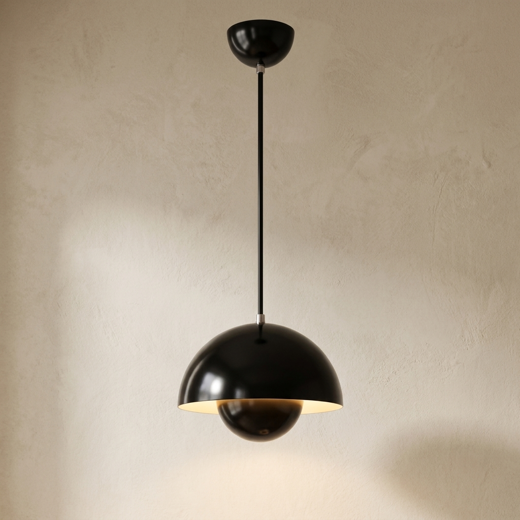 The Bonnet black mushroom pendant light, lit, hanging in front of a lime-washed plaster wall — Selden Home product photography