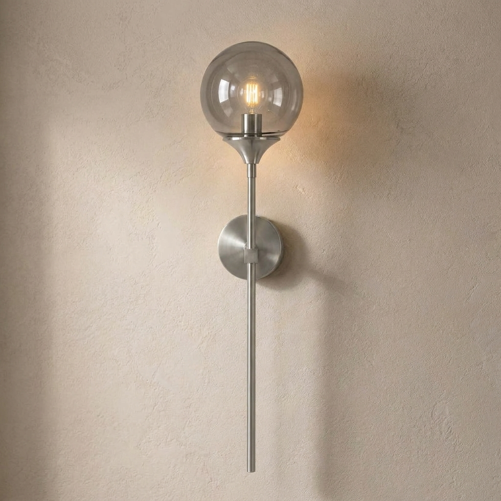 The Reed, silver long-stem wall sconce with smoke grey glass globe, mounted on plaster wall — Selden Home product photography