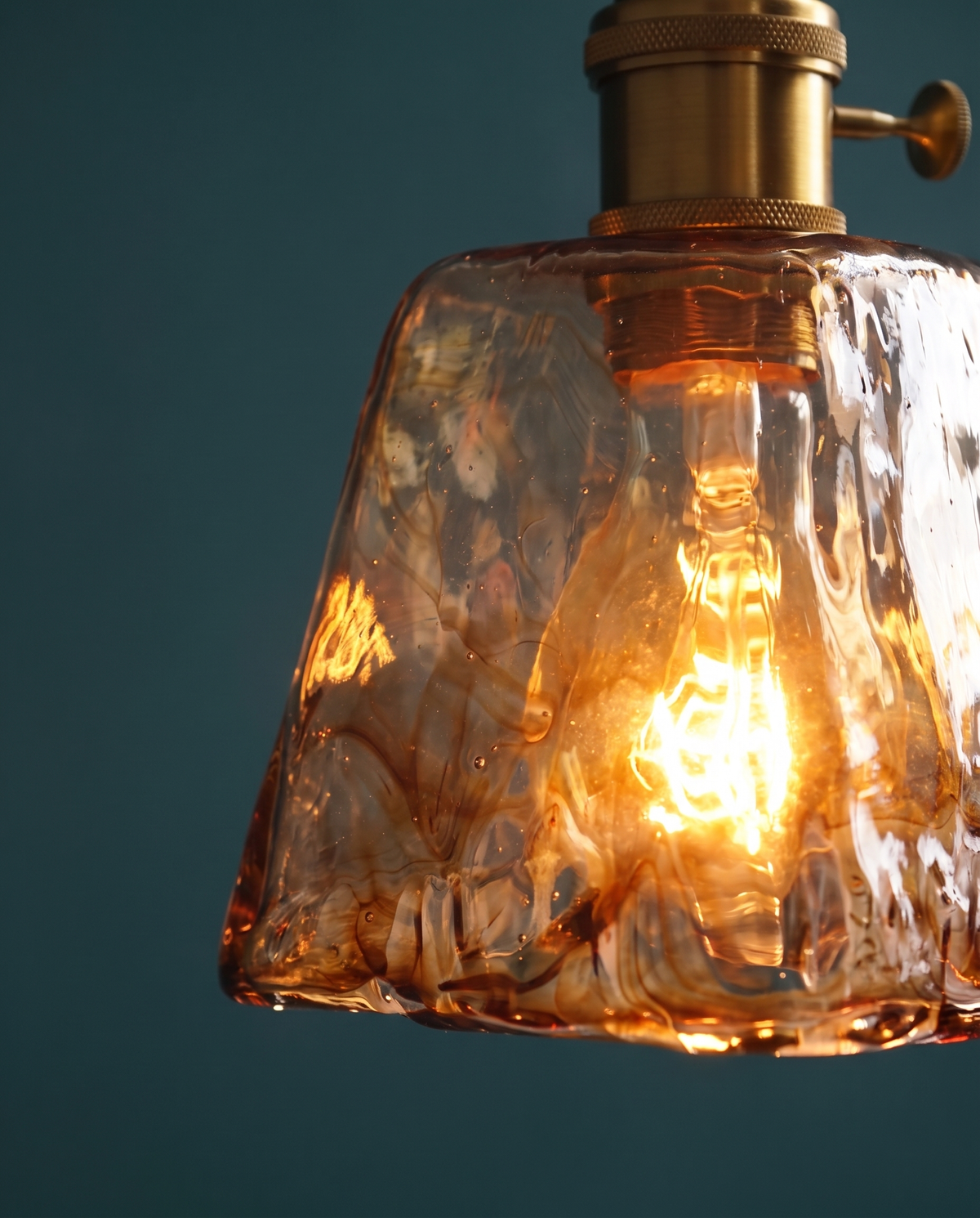 Close-up of The Tumbler's thick textured amber glass, lit