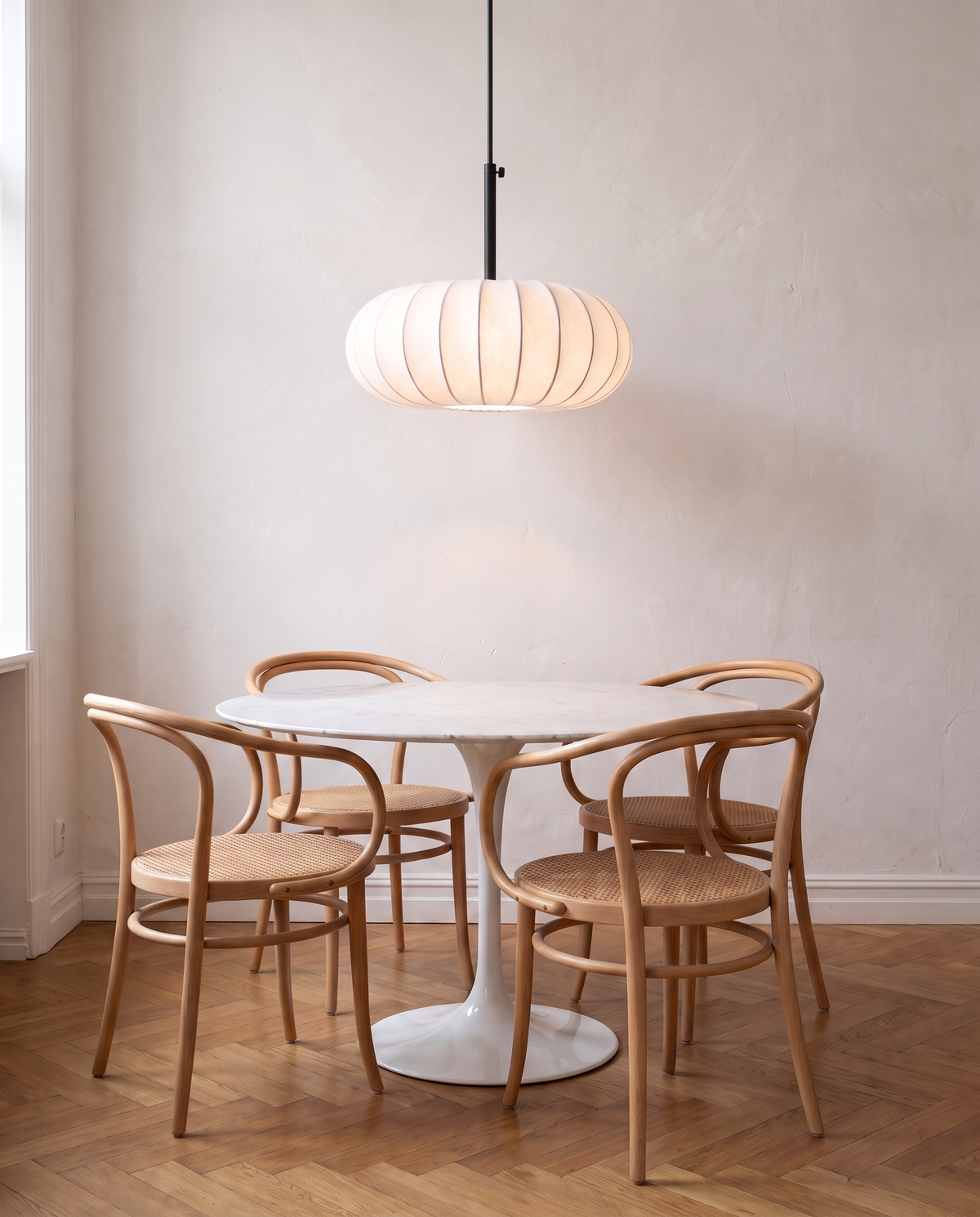 The Veil Pendant over a round marble dining table