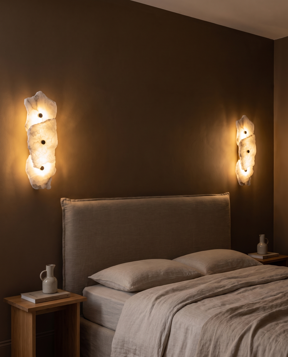 Two Strata wall lights with three heads either side of a bed