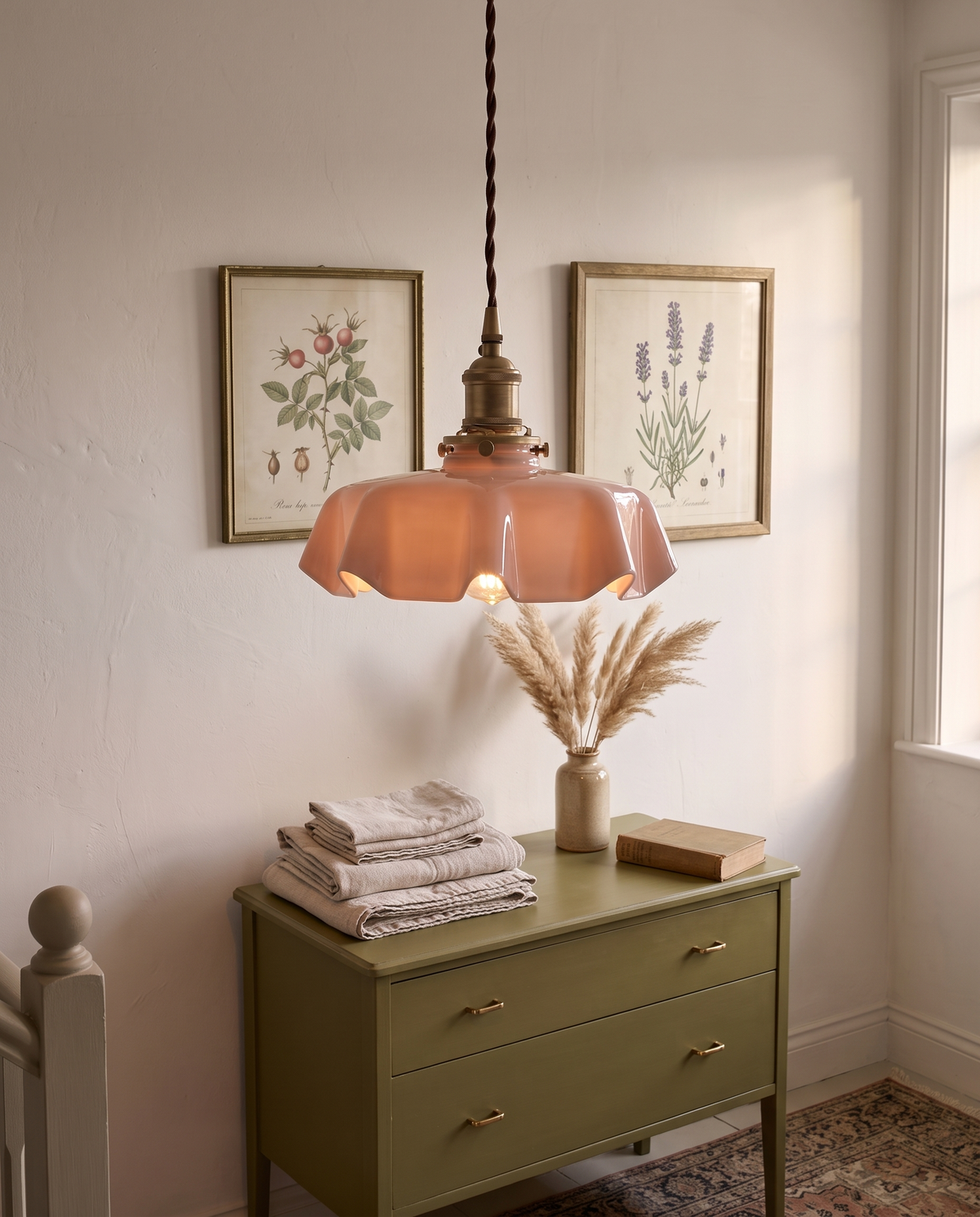The Scallop Pendant in pink above a chest of drawers on a landing