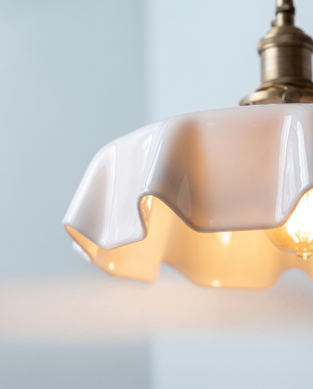 Close-up of the scalloped rim of The Scallop's white glass shade