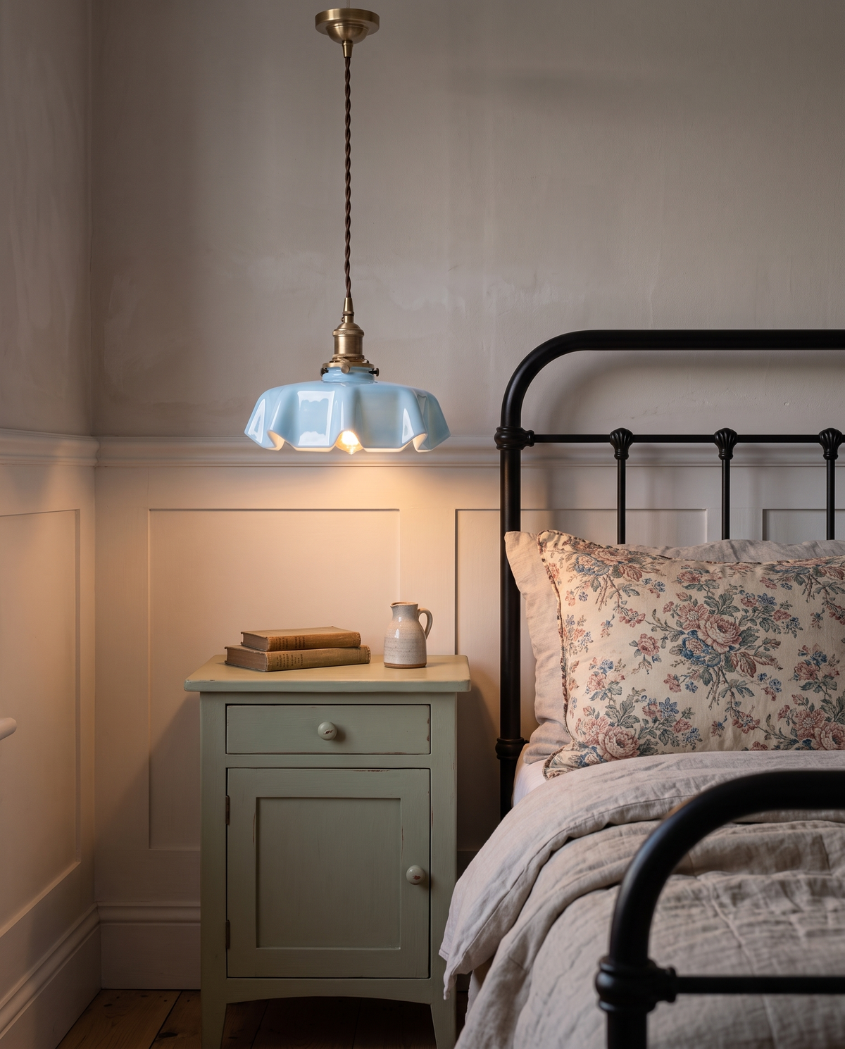 The Scallop Pendant in blue over a bedside table in a panelled bedroom