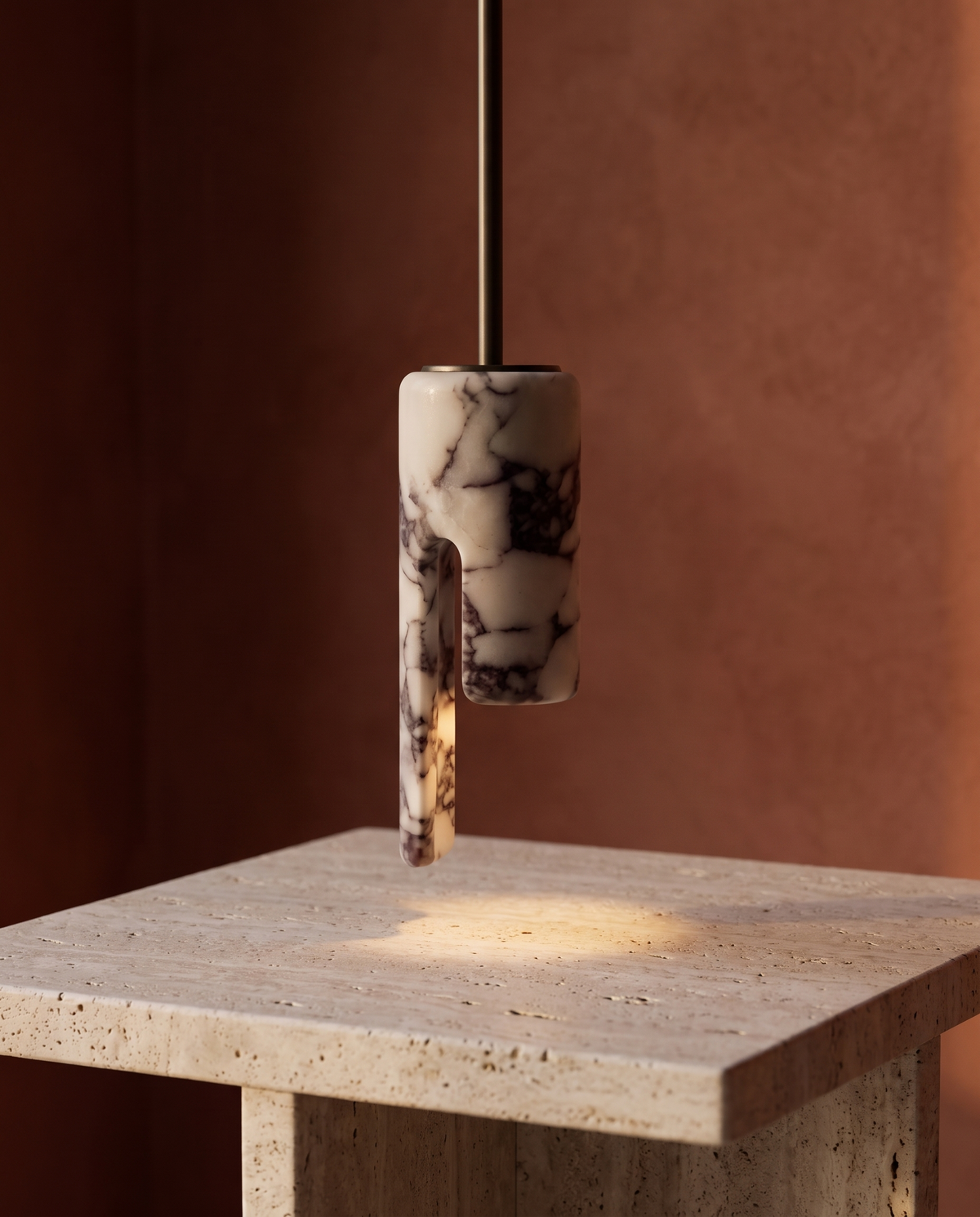 The Flute Pendant hung low over a travertine side table
