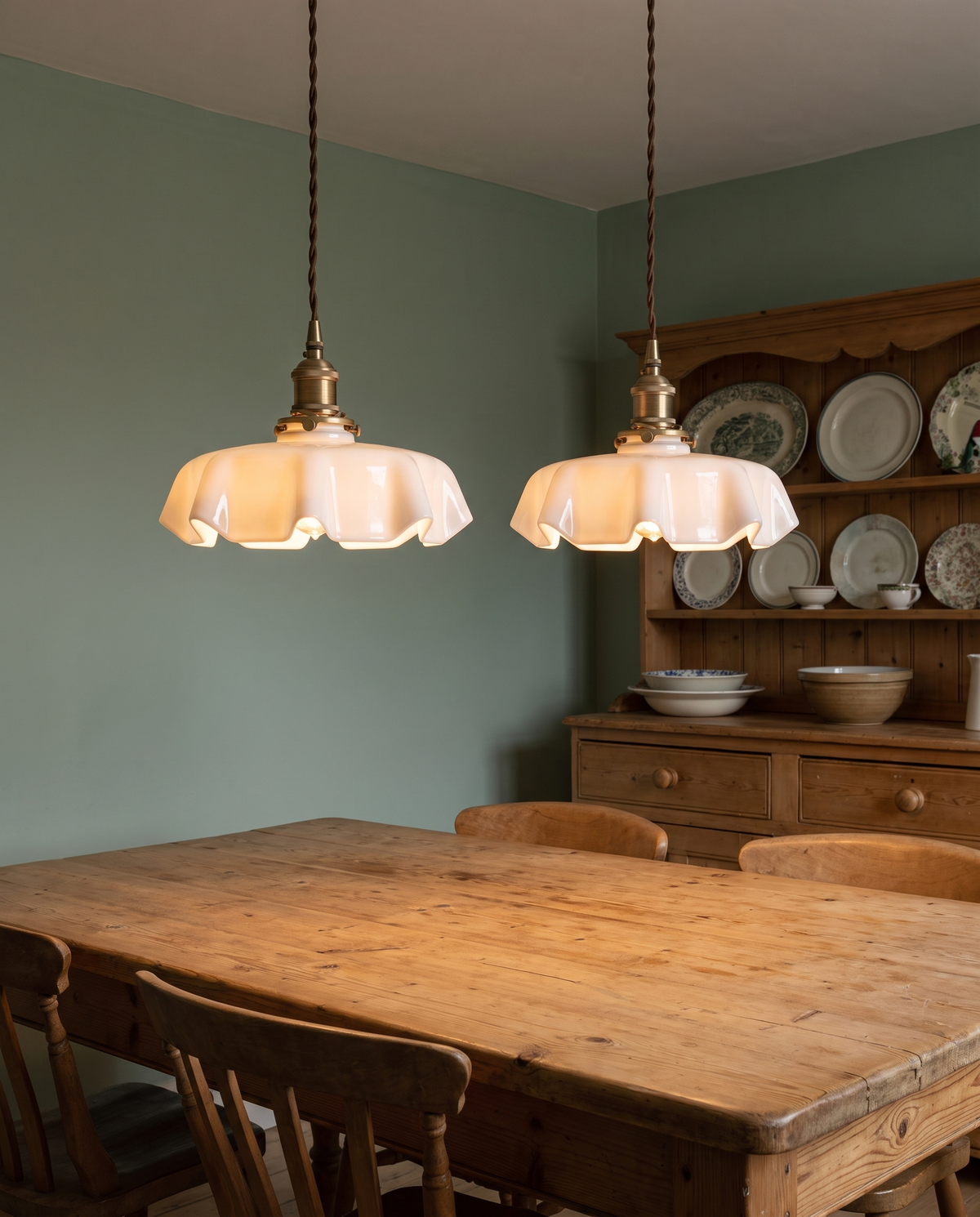 Two white Scallop pendants over a pine dining table