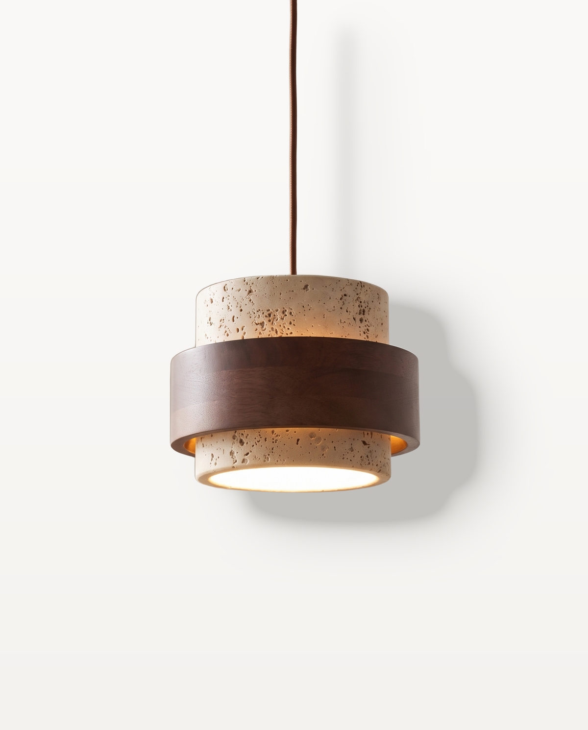 The Bobbin Pendant, travertine drum with a dark wooden band, lit
