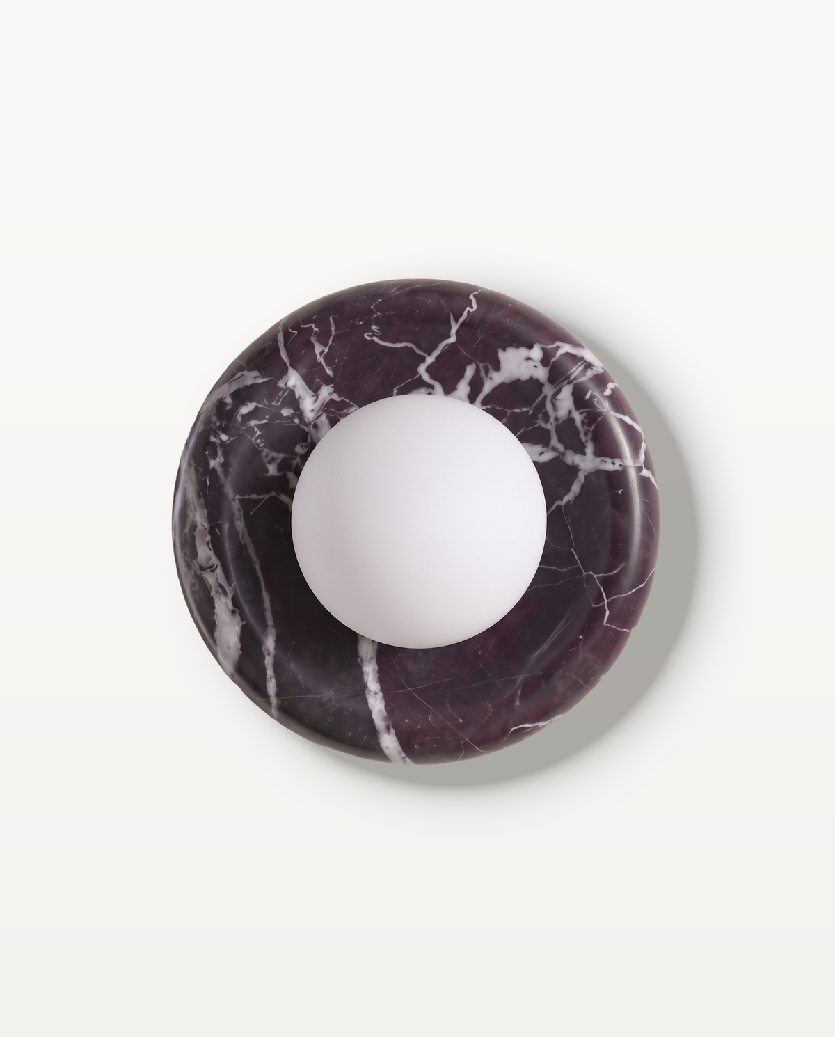 The Cameo Wall Light in Aubergine – a ring of aubergine marble with white veining and a frosted glass globe, seen from the front