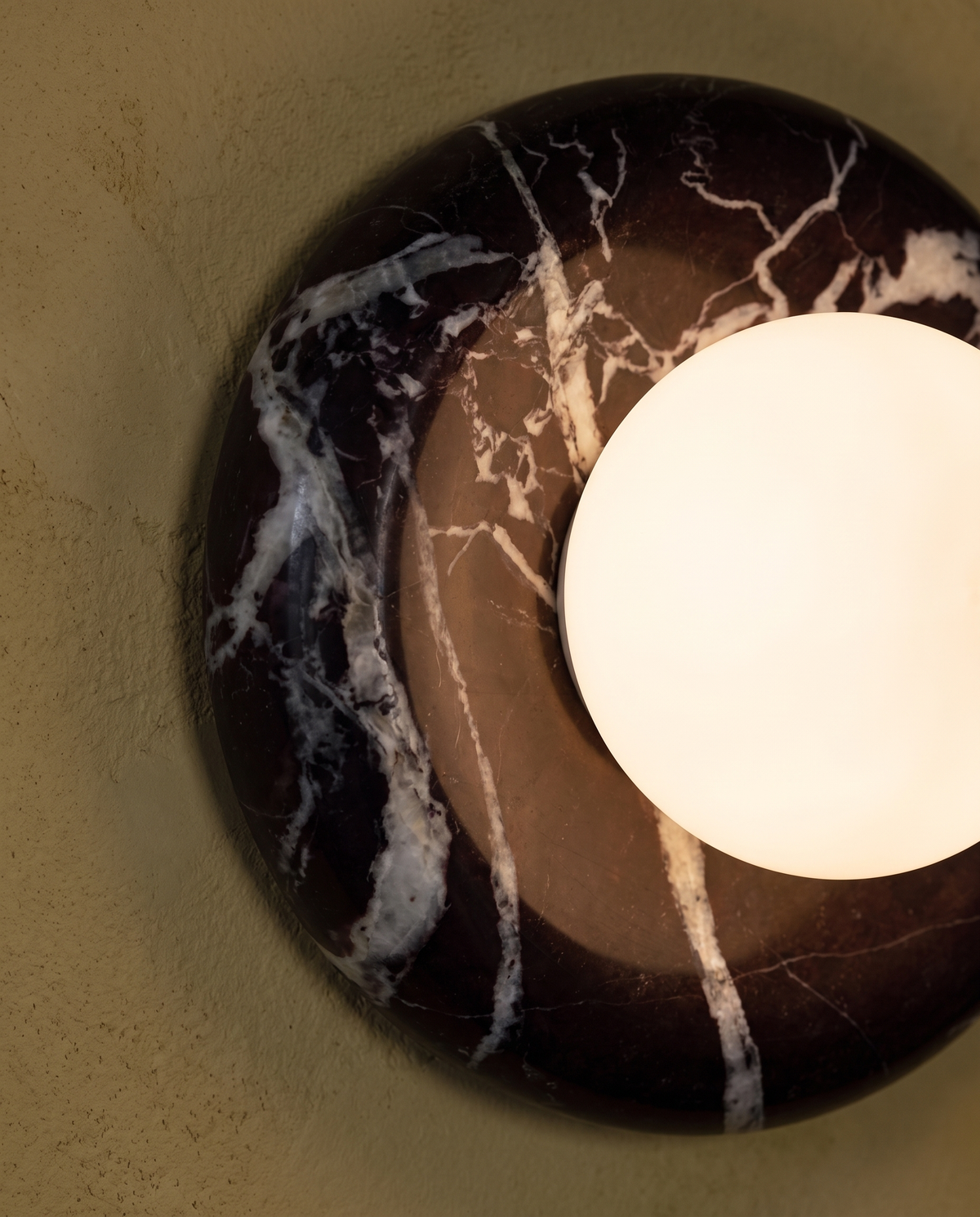 The aubergine marble ring and glowing frosted globe of The Cameo