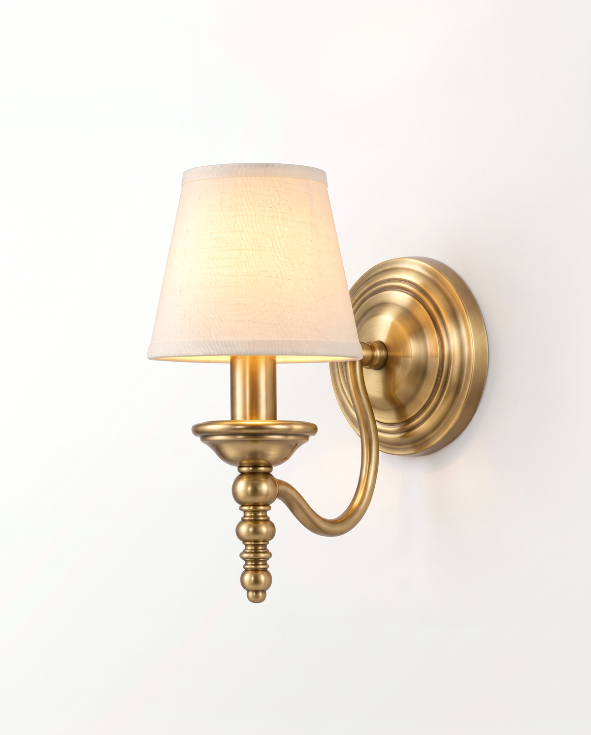 The Candlewick Wall Light in Aged Brass with a small fabric shade