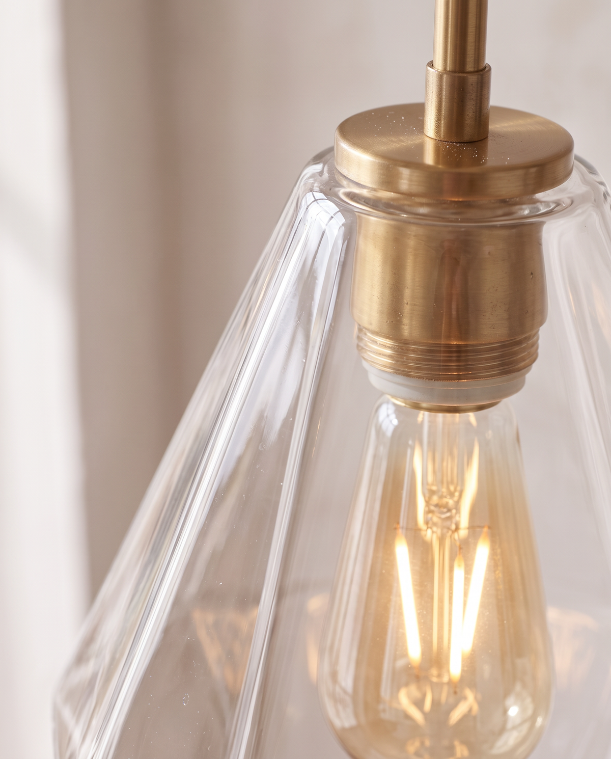 Close-up of the faceted glass and gold-finish holder of The Carafe