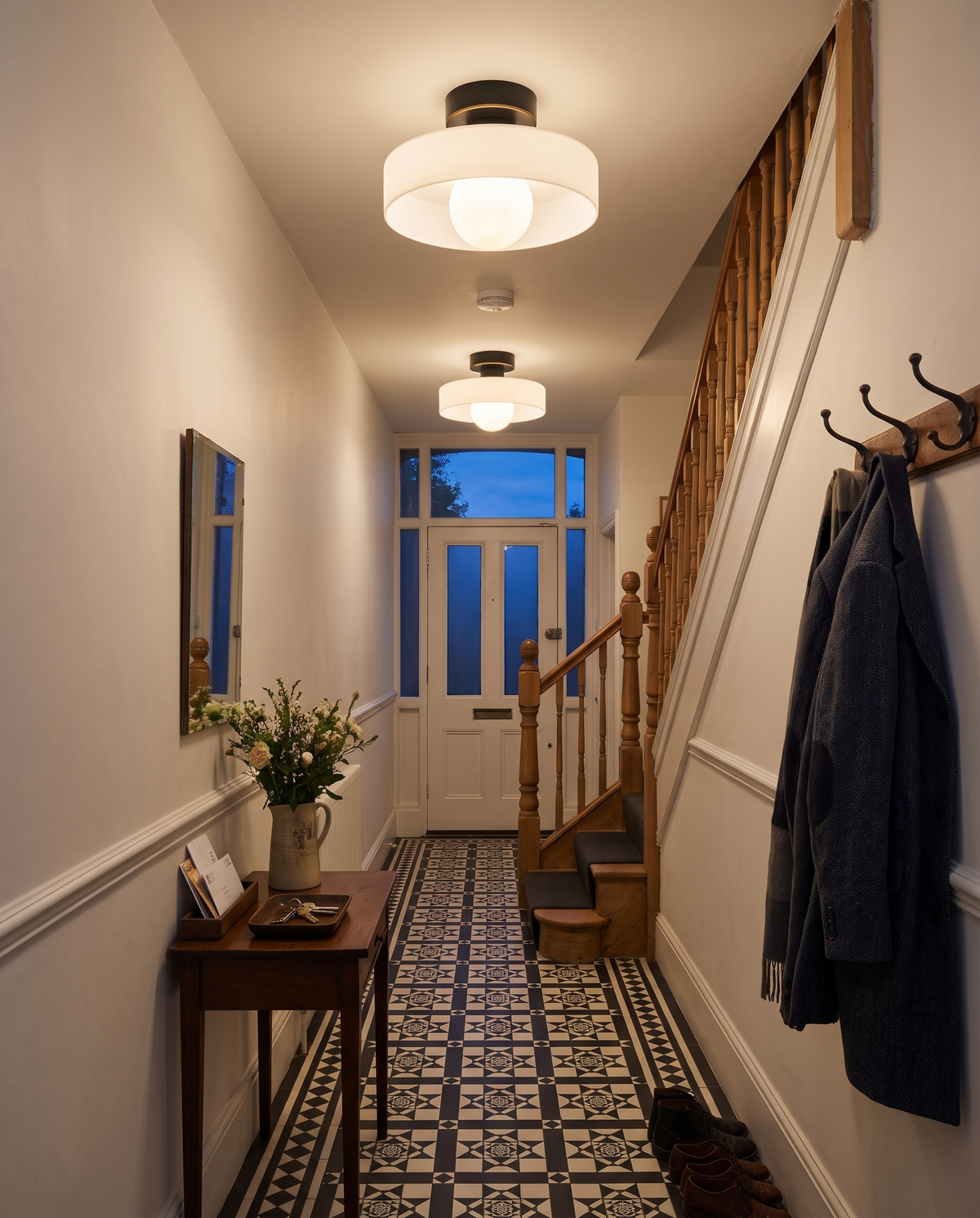 Two Cloche ceiling lights down a Victorian hallway with an encaustic tiled floor