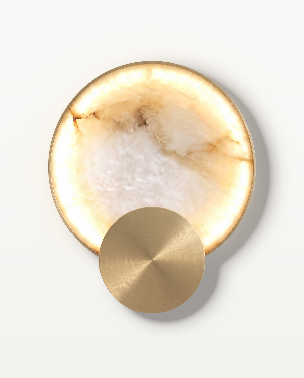 The Eclipse Wall Light – a backlit disc of natural stone with a brushed-gold disc, front view