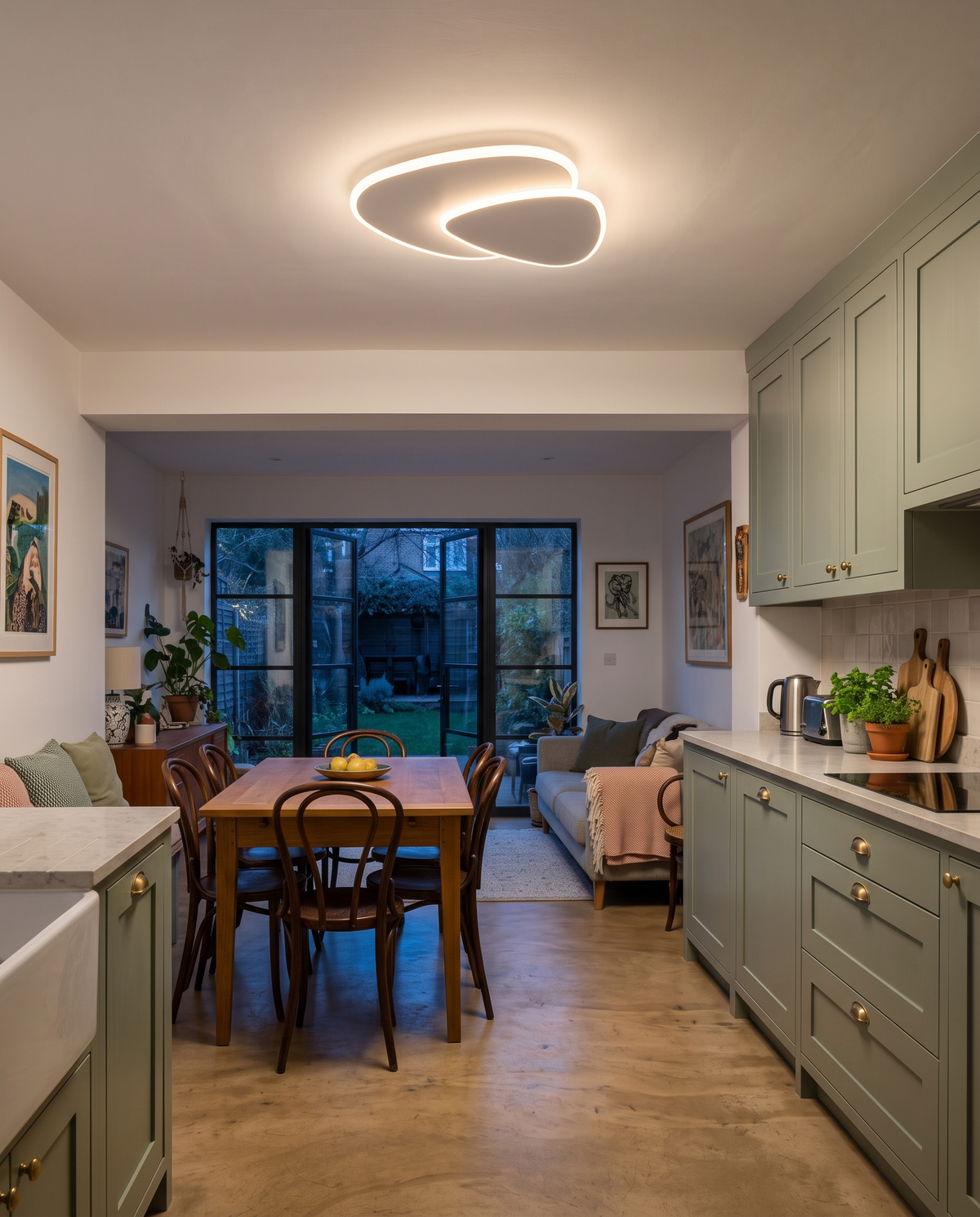 The Facet ceiling light above the dining table of a sage green kitchen extension