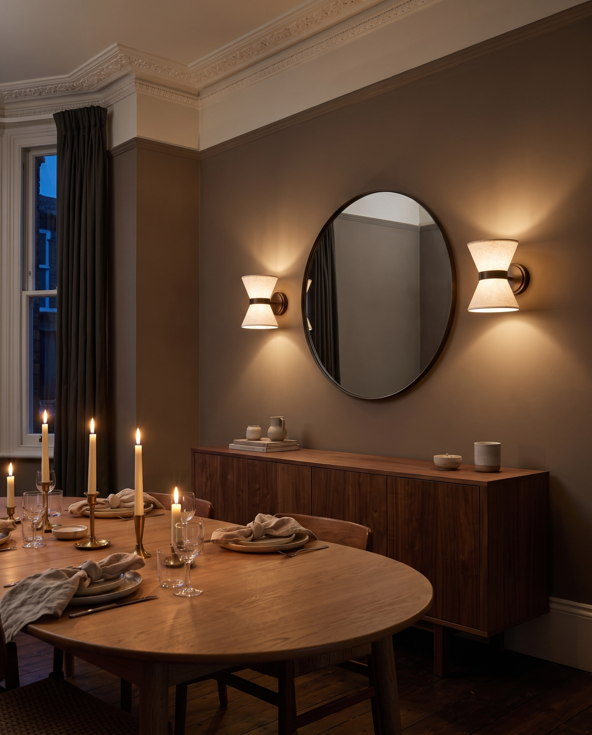 A pair of Hourglass wall lights either side of a mirror in a dining room