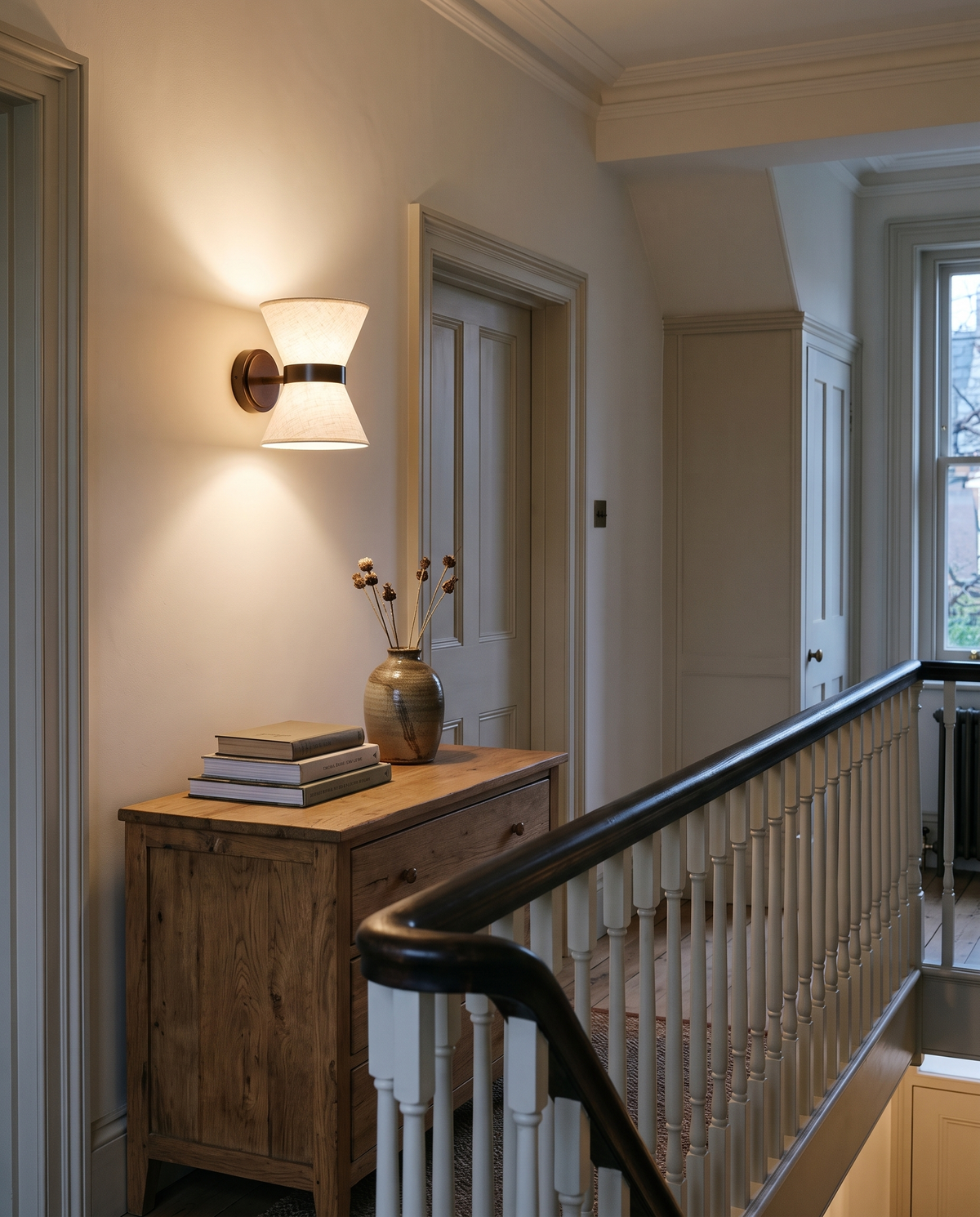 The Hourglass on a townhouse landing above an oak chest