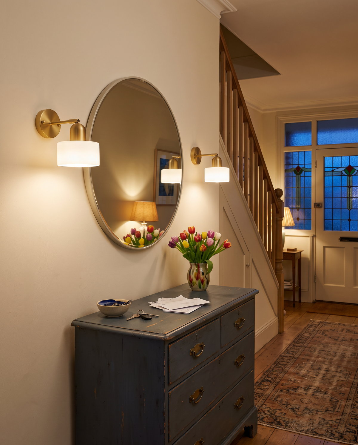 Inkwell wall lights in Opal either side of a round hallway mirror