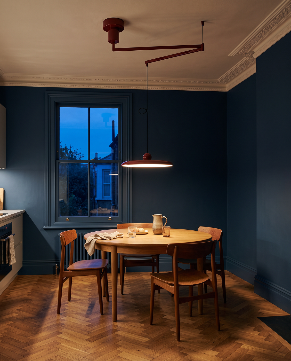 The Jib in Oxblood swung over a round table in an inky blue kitchen-diner