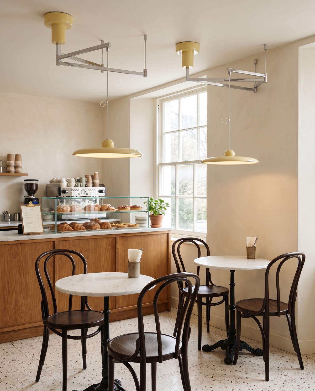 Two Jib pendants in Primrose over café tables in Notting Hill