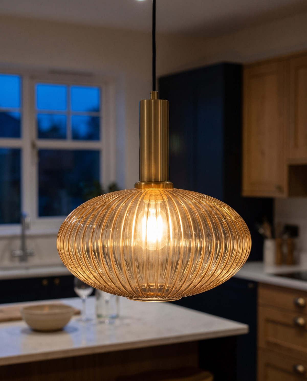 Close-up of the ribbed amber glass and brass-finish fitting of The Larder