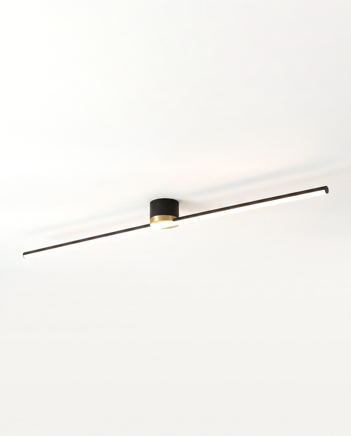 The Lath Ceiling Light in Jet, a slim LED bar on a round canopy, as a downlight