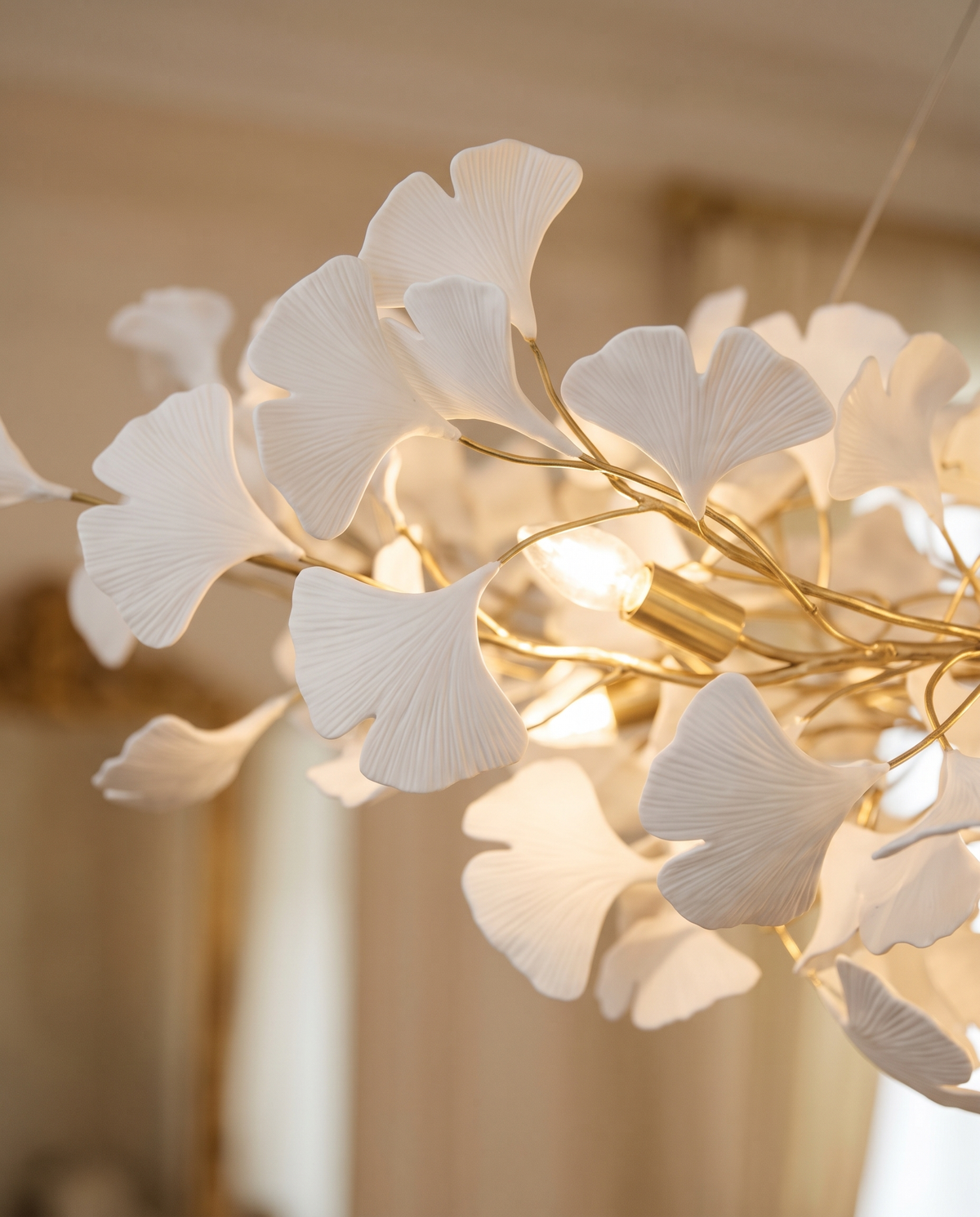 Close-up of the fan-shaped porcelain leaves and gilt branches of The Maidenhair, lit